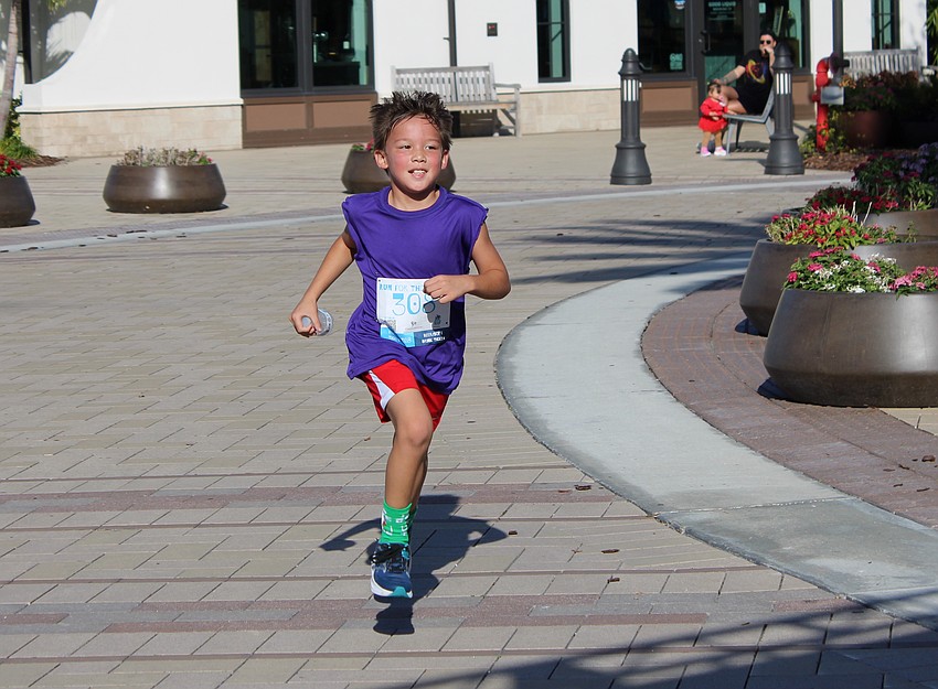 Sarasota 7-year-old Cooper Robenalt had to finish the Run for the Beads in a hurry because he had to play football later in the day.