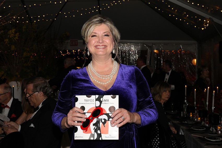 Heather Kasten holds a book about contemporary artist Yayoi Kusama