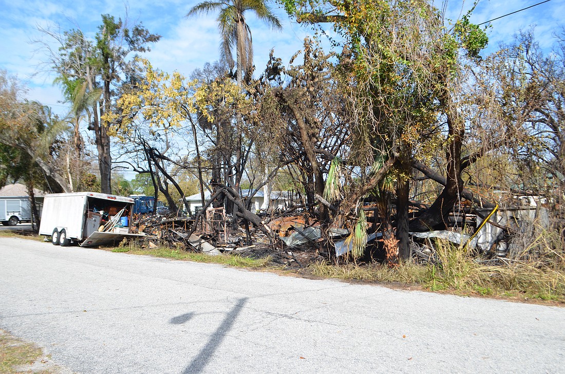Blackened trees stand above the charred remains of James Ward's house at 1013 Ponder Ave.