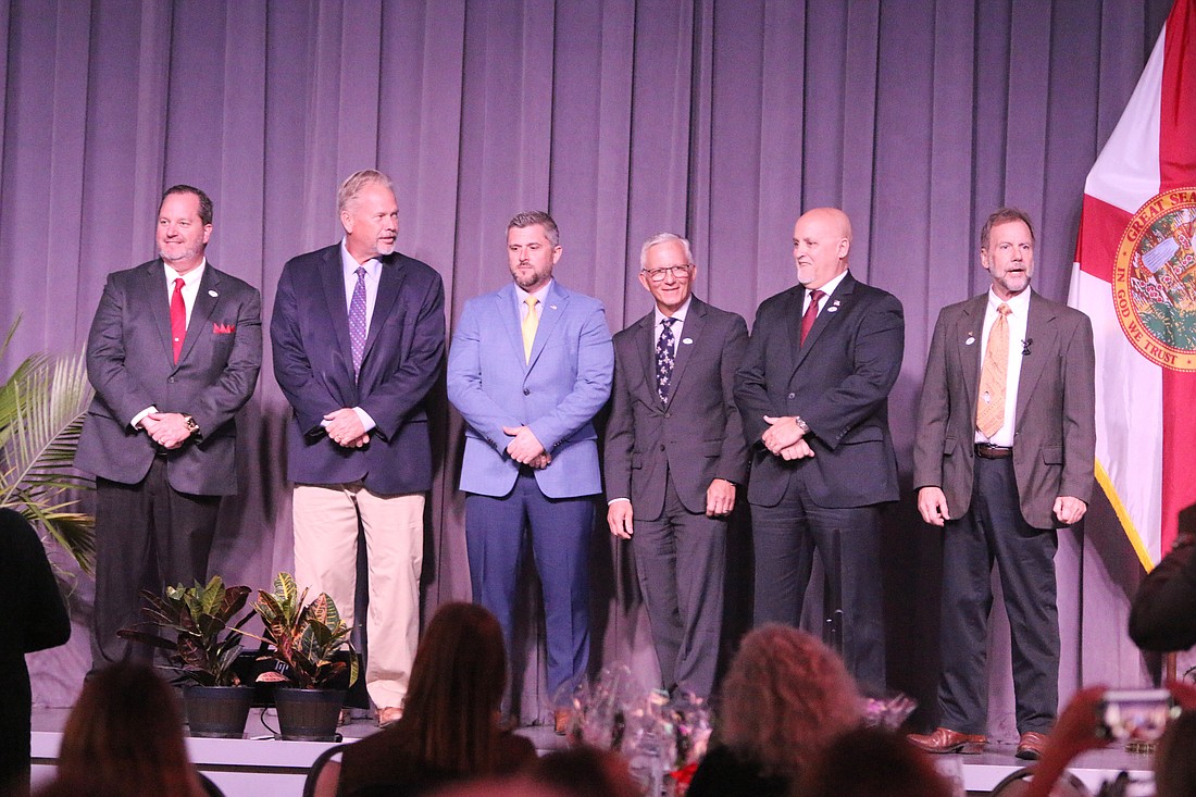 The Volusia County Council — Troy Kent, Don Dempsey, Danny Robins, Jake Johansson, Matt Reinhart and Jeff Brower — stands onstage after the 2024 State of the County on Wednesday, Feb. 14. Photo by Jarleene Almenas