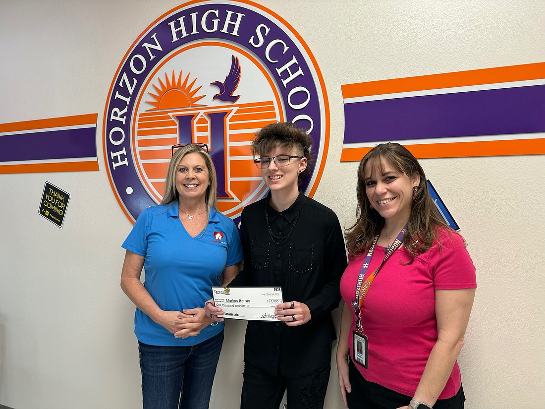 Markus Barras accepted a $1,000 check from essay sponsor Amy Kidwell, left, of Heart and Home Orlando. With them is Marcal Joyner, Markus’ favorite teacher, who received a $100 gift certificate.