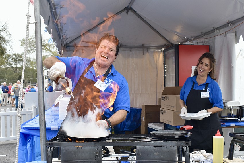 Zack Kallis uses brandy to light up the saganaki as Renee Amoratis looks on.
