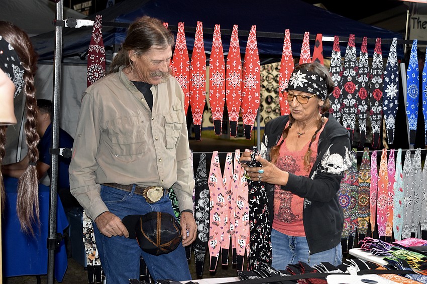 Brian McCabe gets help from Connie McCabe with choosing a headwrap, at Headwraps by Connie