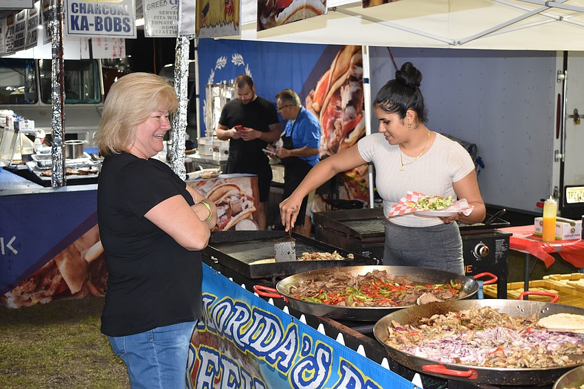 Leslie Thomas gets a helping of dinner from Veronica Rodriguez.