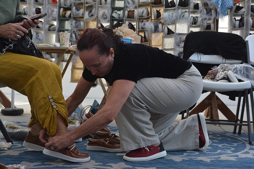 Gloria Rincon helps a customer with her shoe fit at Pepós Shoes.