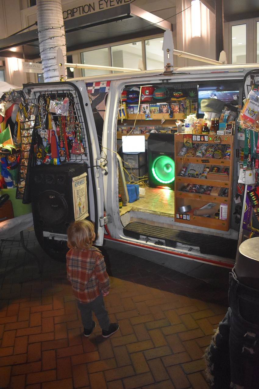Waylor Bystrom, 2, is captivated by the display inside the van of Dreadlock DaCity.
