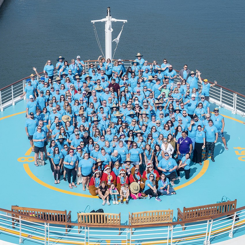 The cruise ship's helipad is covered in a sea of blue as 250 MVP Sports and Social members gather for a photo.