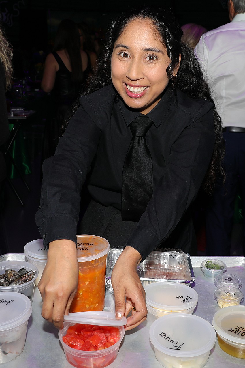 Michael's On East server Maricielo Vasquez preps the chef stations at each table