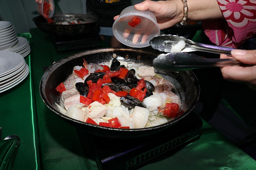 Table chefs prepare East Avenue Bouillabaisse at the Cooking for Wishes gala with chef Jamil Pineda