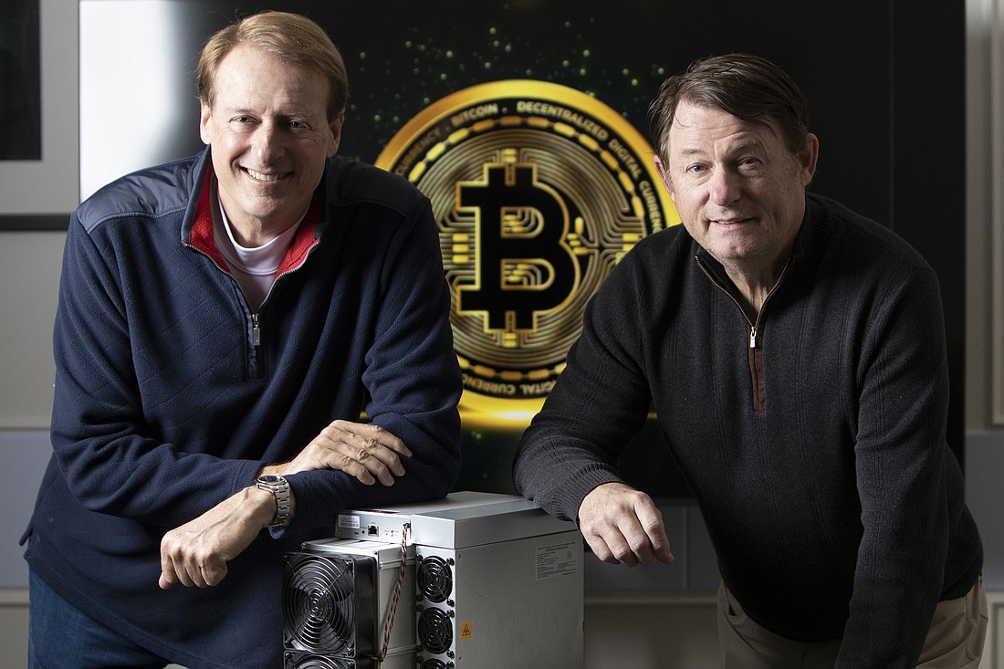 LM Funding America's CEO Bruce Rodgers and CFO Richard Russell, in their Tampa office with a Bitcoin-mining machine.