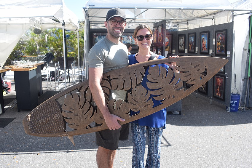 Matthew and Sarah Lembo with a repurposed surfboard by Jim Rajner.