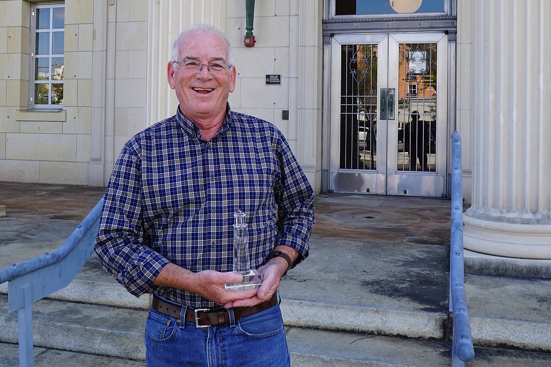 Sarasota Bay Estuary Program Executive Director Dave Tomasko holds his Climate Champion award.