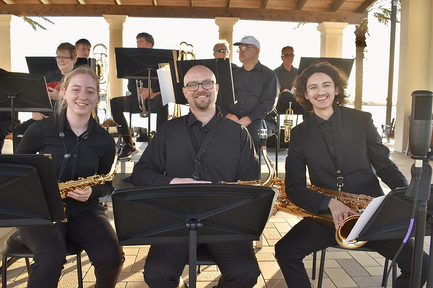 Out-of-Door Academy junior Celia Rayman, math teacher Michael Saxton and senior Joe Clarke get ready for their performance at Waterside Place on Feb. 27.