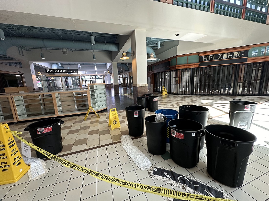 Trash containers are positioned to capture rainwater leaking from the ceiling at Regency Square Mall.