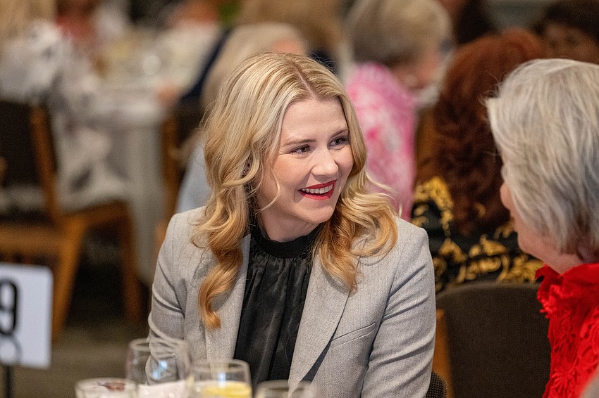 Speaker Elizabeth Smart chats with table guests.