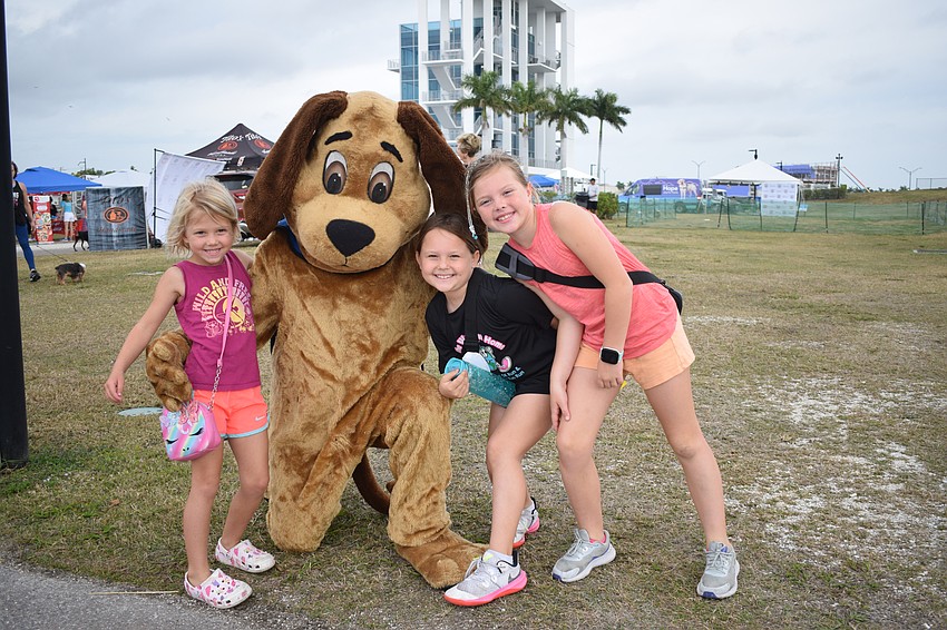 Sarasota 5-year-old Mia Slates has fun with Scout, the Southeastern Guide Dogs' mascot, Sarasota 8-year-old Harper Krull and Sarasota 9-year-old Cali Slates before the Suncoast Walkathon begins.