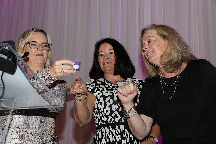 Emcee Summer Smith, and Signature Luncheon Co-chairs Kathy Martella and Julie Delaney, draw the winning tickets for a Ritz-Carlton, Sarasota package.