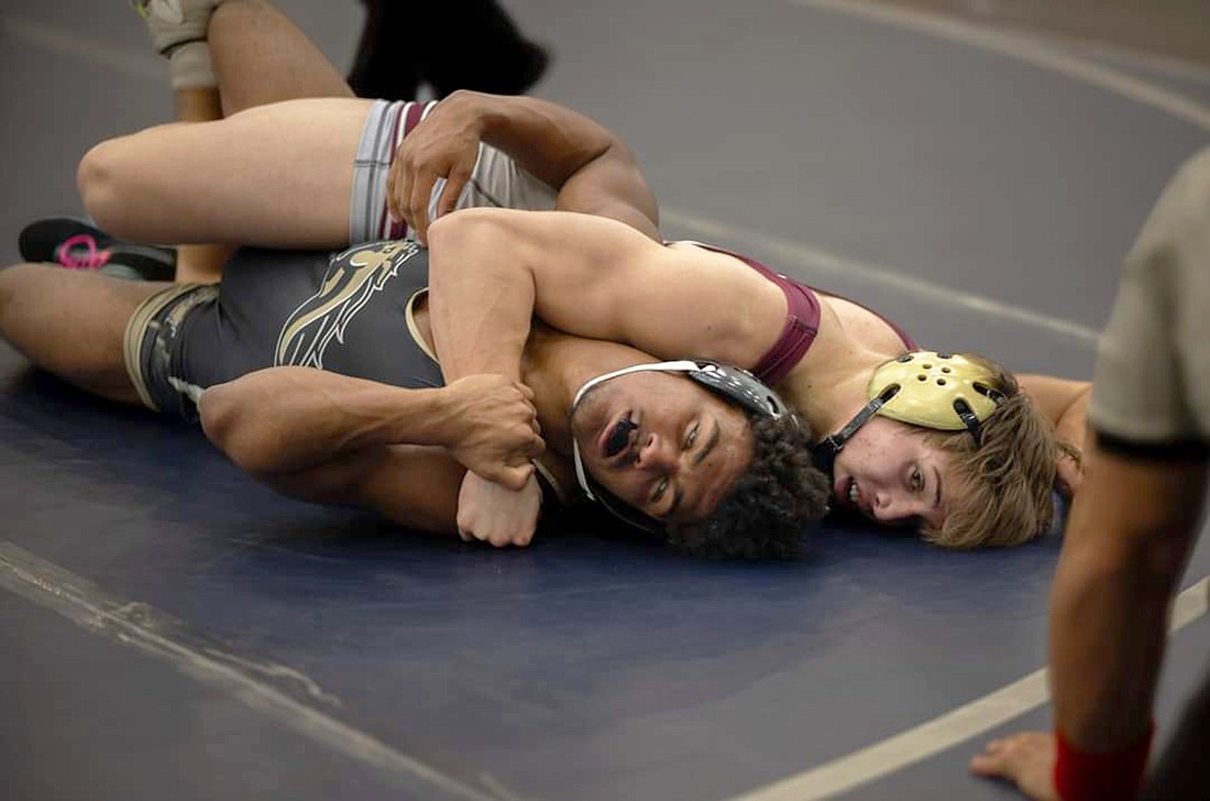Braden River High senior wrestler Gage Wiggins (right) tries to pin Mitchell High's Bishop Taylor in the district tournament. Wiggins finished second in Class 2A at 165 pounds at the state tournament on March 2.