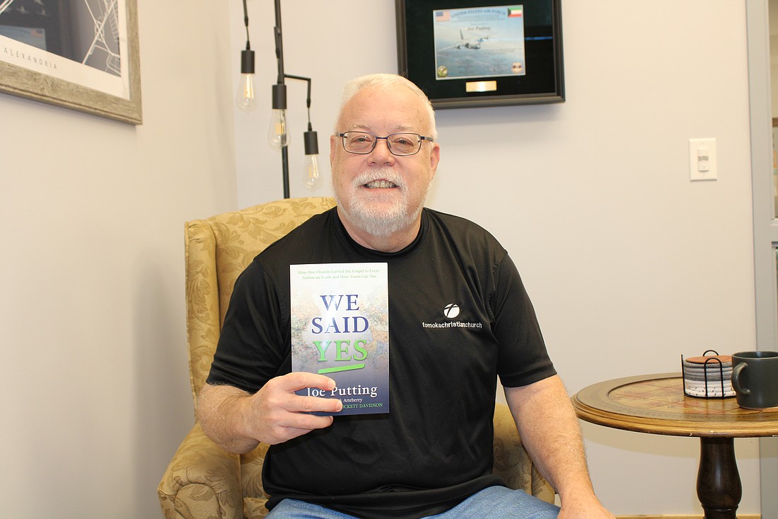 Tomoka Christian Church Pastor Joe Putting holds his book "We Said Yes." Photo by Alexis Miller