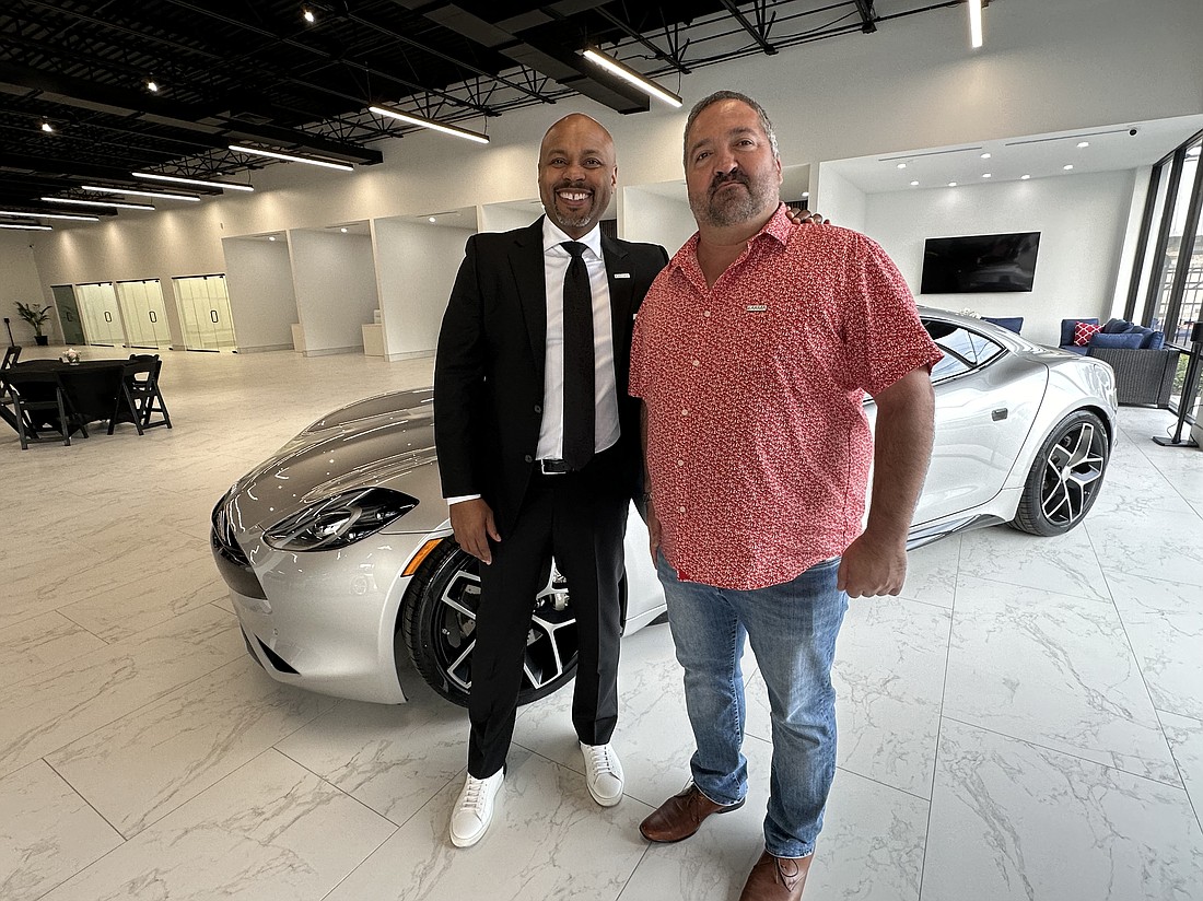 Karma Automotive President Marques McCammon and Karma Jacksonville owner Val Ranguelov in front of the Karma Revero at the dealership’s grand opening March 7.