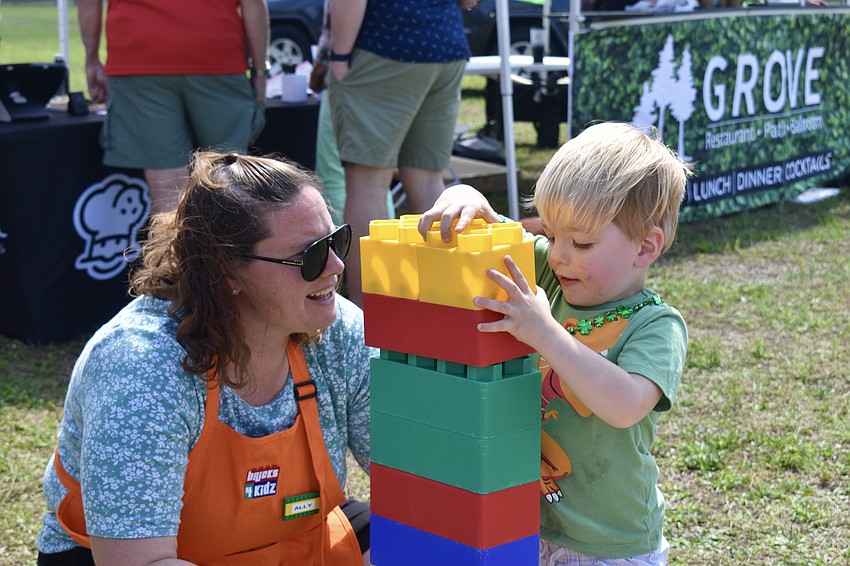Ally James with Bricks 4 Kidz helps Sarasota resident Henri Smith build a brick tower.