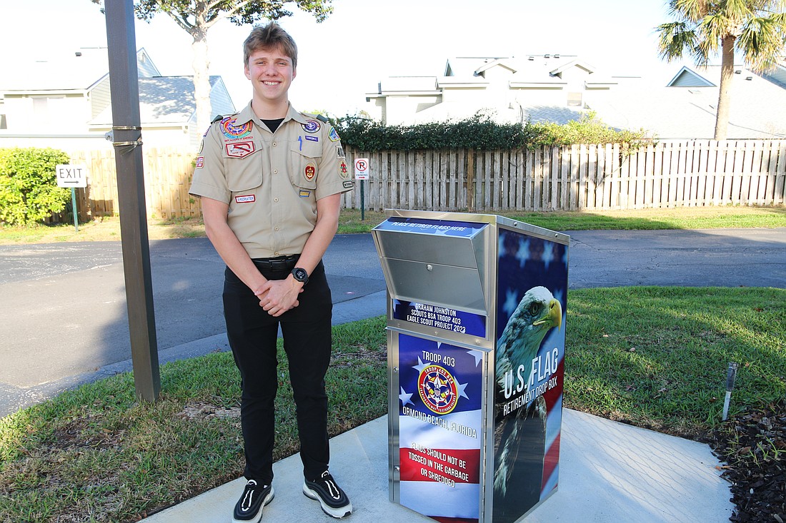 Graham Johnson stands next to the U.S. flag retirement drop box at Lighthouse Presbyterian Church. It is one of two he installed in town as part of his Eagle Scout service project. Photo by Jarleene Almenas