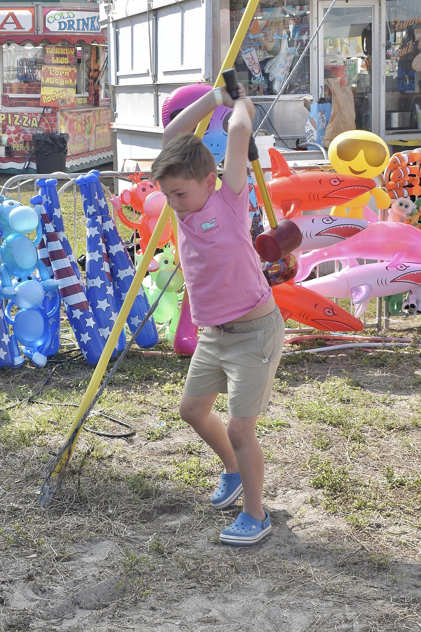 Chase Treadwell, 7, prepares to make a swing in the strongman game.
