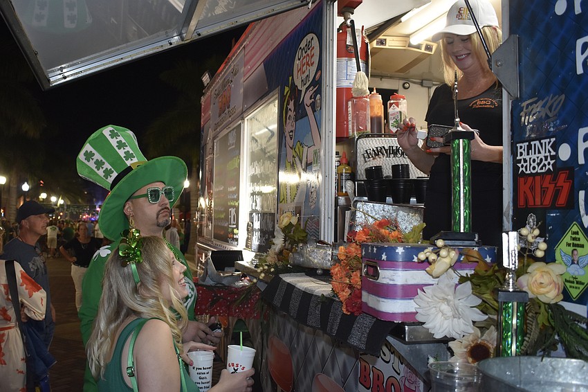 Tommy Hill and Sarah Schmitz order a meal from Lora MIller of Smokin' Momma Lora's BBQ.