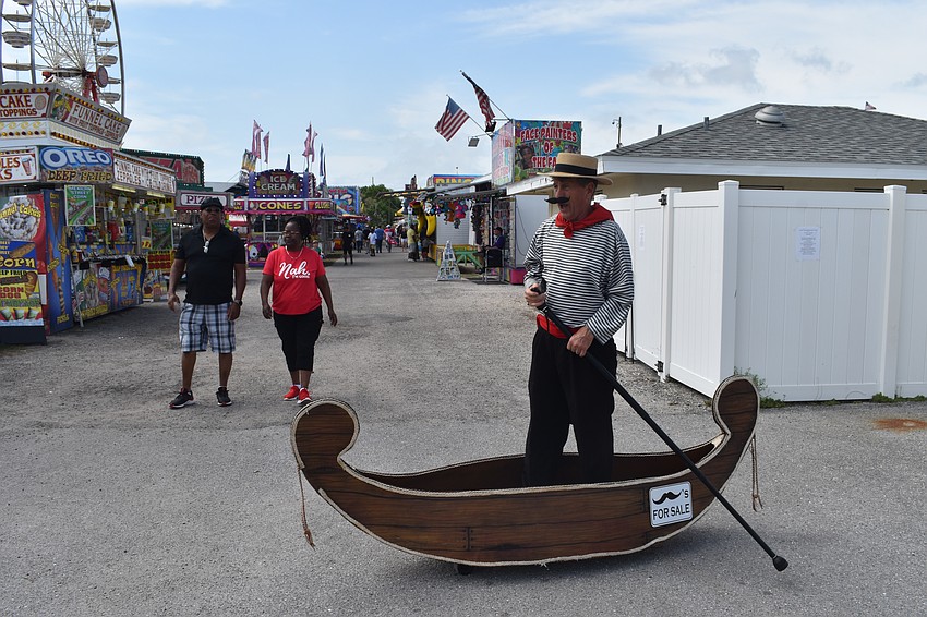 Joe Rainey and Marsha Kirksey watch as Steven Lombardo of Fritzy Brothers One Man Circus sails by.
