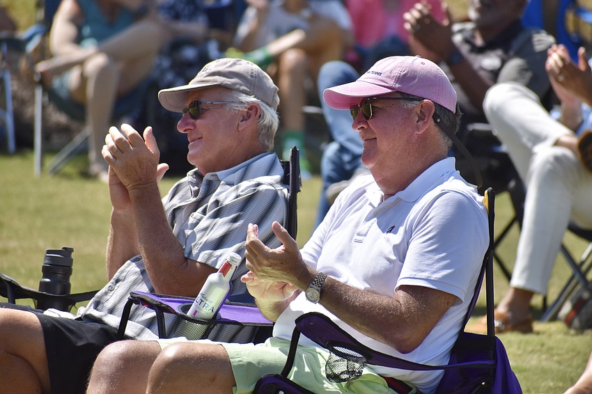 Ralph Lerous and Tim Dumas applaud the performance by Booker High School students.