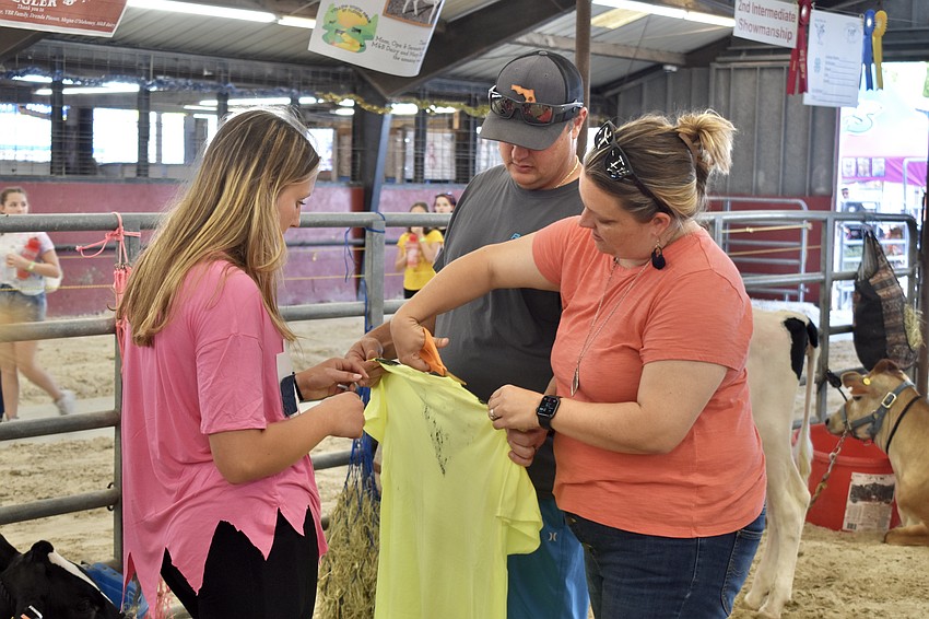Rilyn Stiegler, 10th grade, wearing a ghost costume, makes a Pac-Man costume for her cow Nova, with Bailey and Ronnie Stiegler.