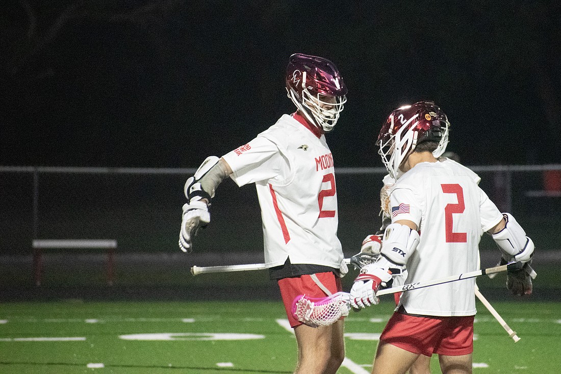 Cardinal Mooney senior Carter Westendorf high fives senior Gio Zanoni after a Zanoni goal against IMG Academy. The Cougars would win 11-10 in overtime.