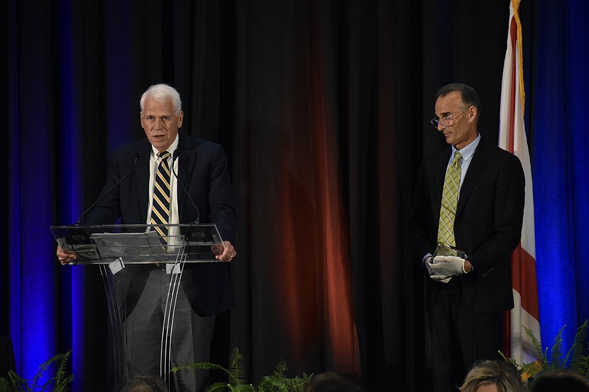 Spirit of Sarasota award recipient Charles D. (Dan) Bailey Jr. offers a speech and prepares to receive the award from Darrin Rohr of HH Staffing Services.