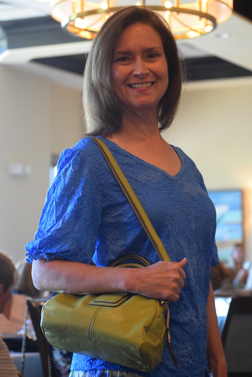 River Strand's Sue Harbaugh shows off every aspect of her outfit including the purse.