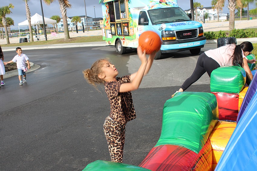East County's Isizabell Williams, 7, enjoys a basketball game while her mom mans the Kona Ice truck in the background.