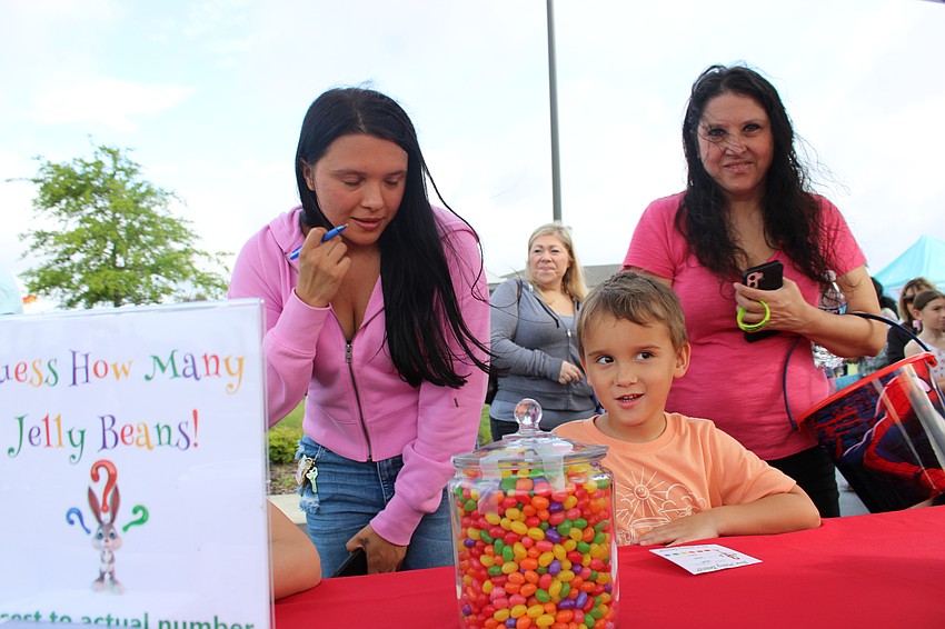 Kaitlyn Stock watches as her son, Lane Watters guesses the number of jelly beans in the jar in a game sponsored by the East County Observer at Eggstravaganza.