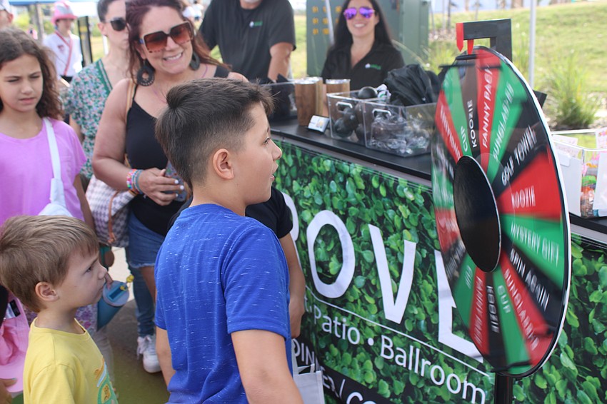 Maximioiano Escobar spins the Grove's wheel of fortunate at Eggstravaganza. The Grove was one of the event sponsors.