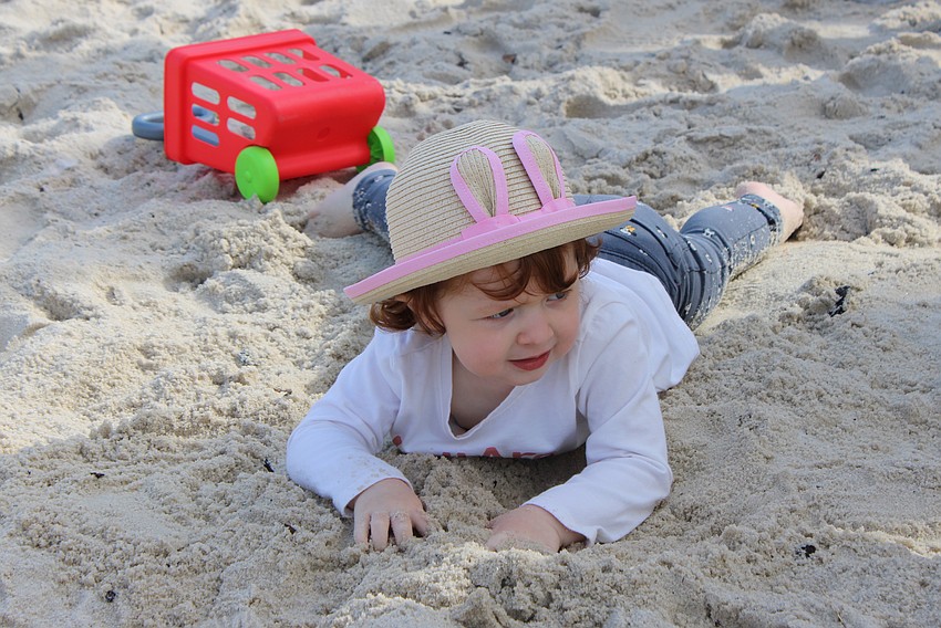 Palmetto 2-year-old Everleigh Flynn put her Easter basket down at Eggstravaganza March 23 at Waterside Place to concentrate on playing in the sand.