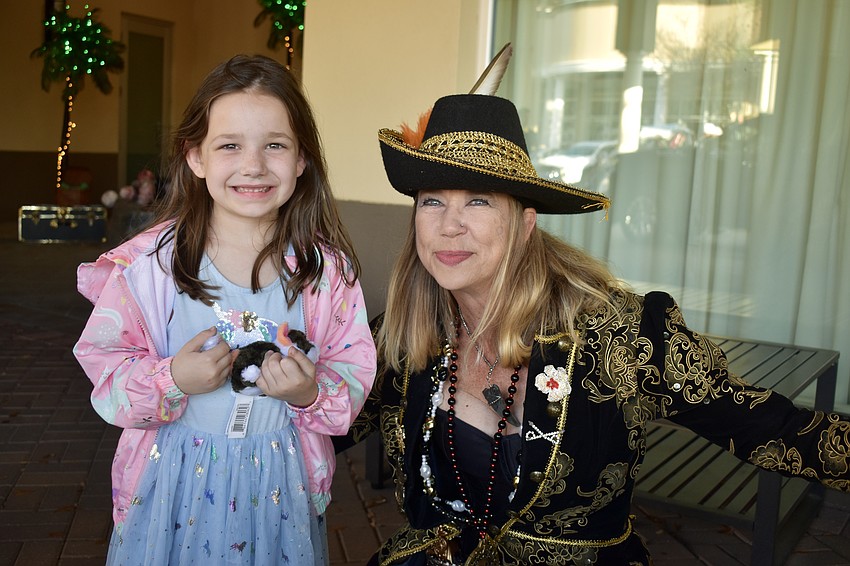 Sarasota resident Zoey Headings isn't attending the event, but stops to get a photo with pirate Ava Lasseter.