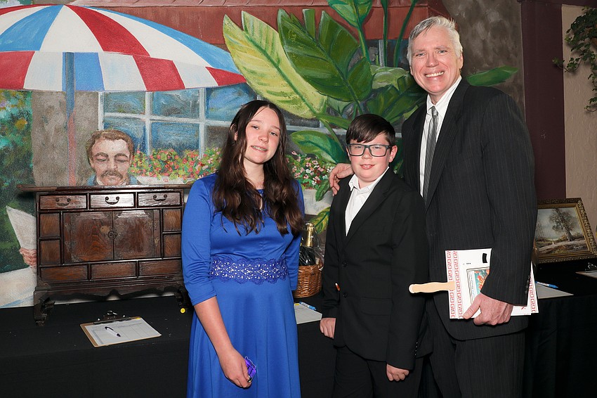 Calla and Harry Kinnan peruse the silent auction items with their dad, Chris.