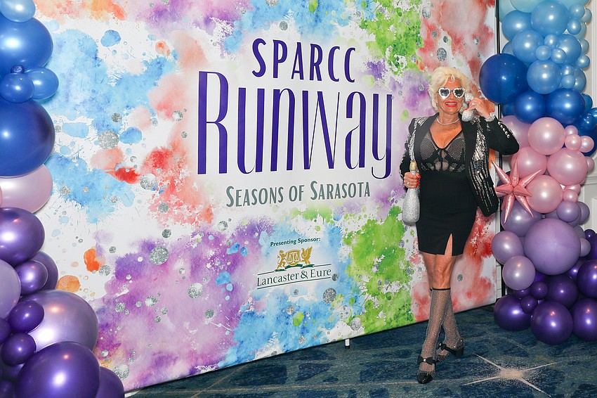 Cha-Cha Sunshine stops at the step and repeat for a quick photo.