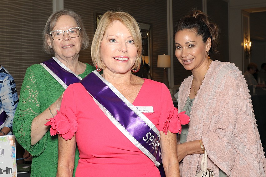 Deborah Bevis gets a hand with her sash from Kathy Finnerty and Layla Rose