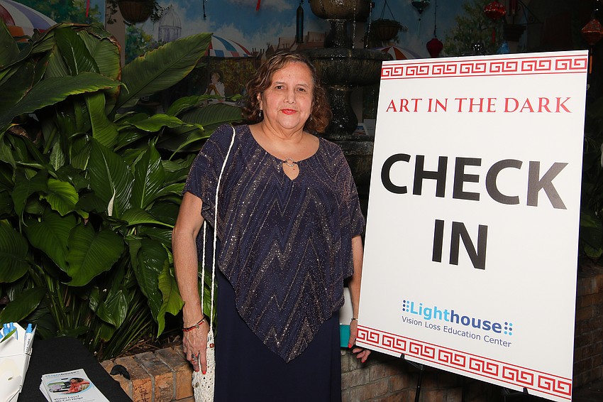 Luz Rubio assists with check in for the Lighthouse Art in the Dark gala.
