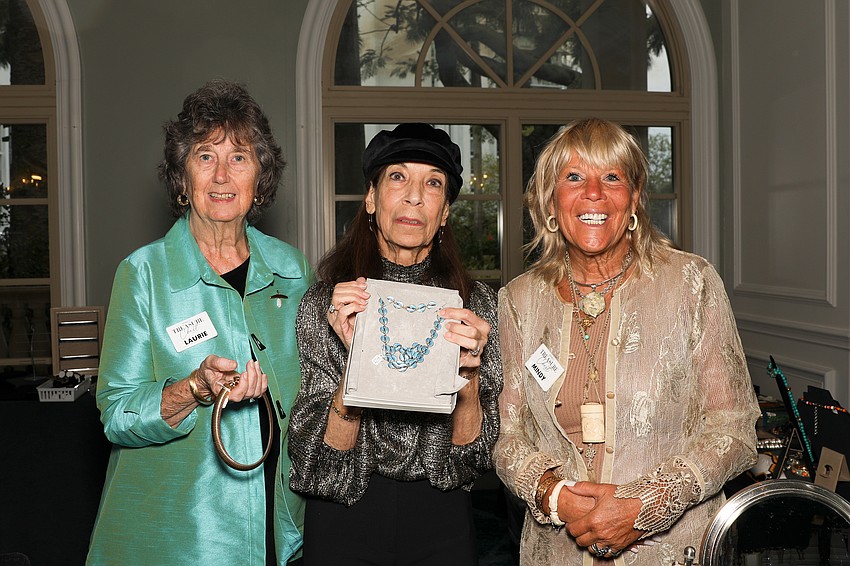 Volunteers Laurie Etter, Marilyn Highland, and Mindy Skura with some pieces that are for sale at the SPARCC fashion show.