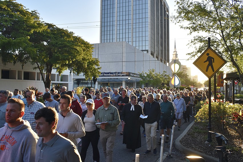 The crowd proceeds down Main Street.