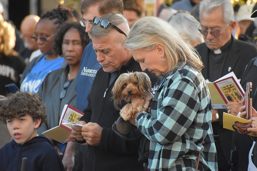 Michael Panebianco, Lola and Gina Hatenyi pray at one of the stations.