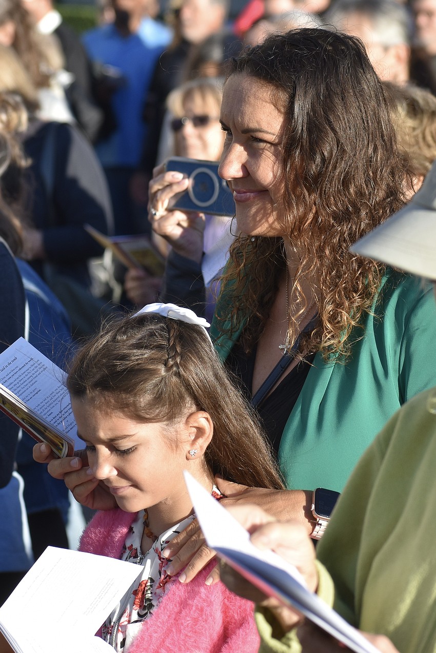 Lucy Sanchez, 9, and her mother Dorota Sanchez, listen to a speaker.