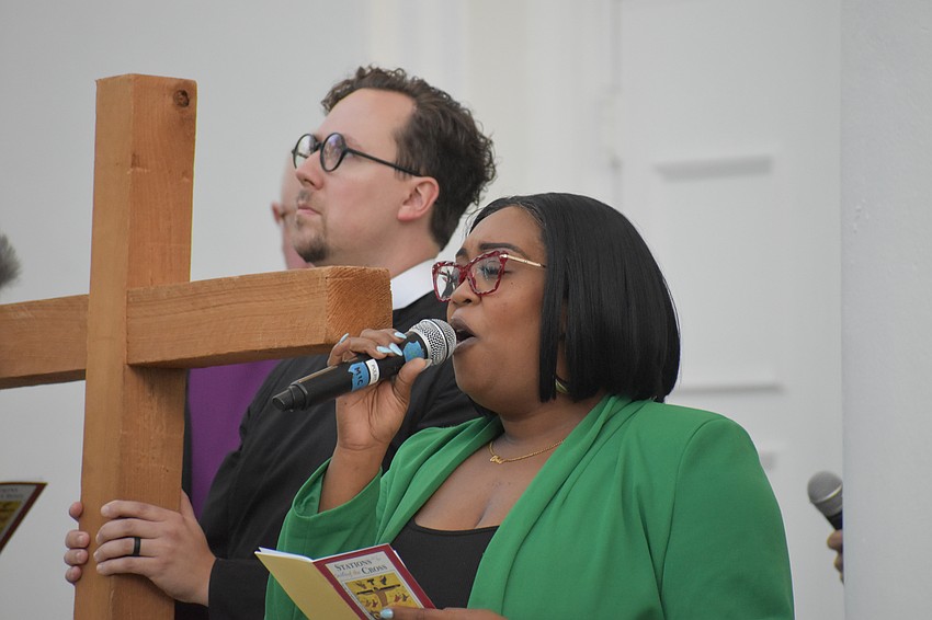 The Rev. David M. Svihel holds the cross as Ariel Blue of Evergreen Church and Westcoast Black Theatre Troupe sings, on the steps of First Sarasota.