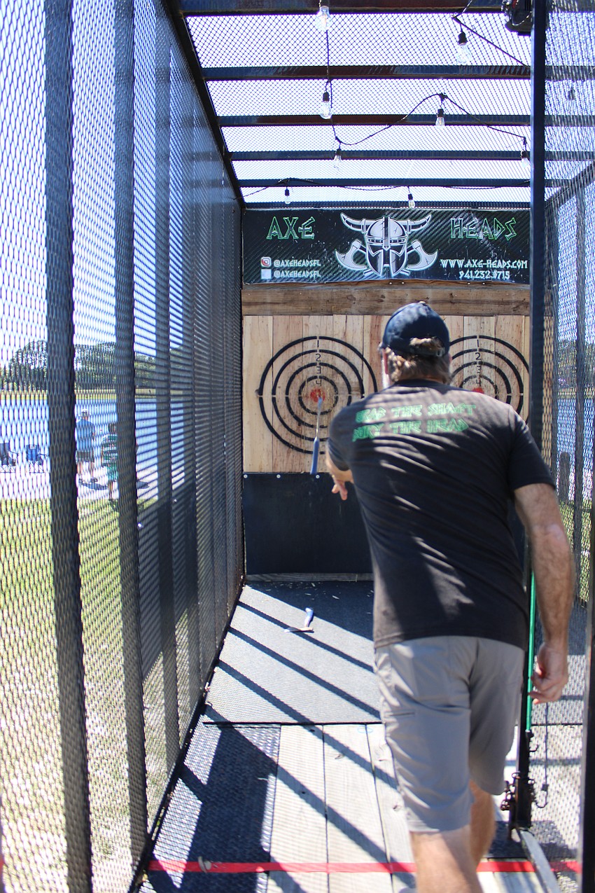 Owner Greg Garrison lands an underhand axe throw on the bulls-eye Friday at Nathan Benderson Park. He brought his concession 