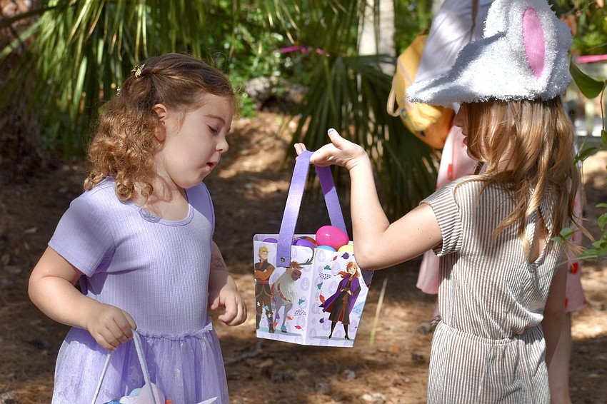Amelia Johnson, 6 and Saylor Thompson, 6 look over the results of an egg hunt.